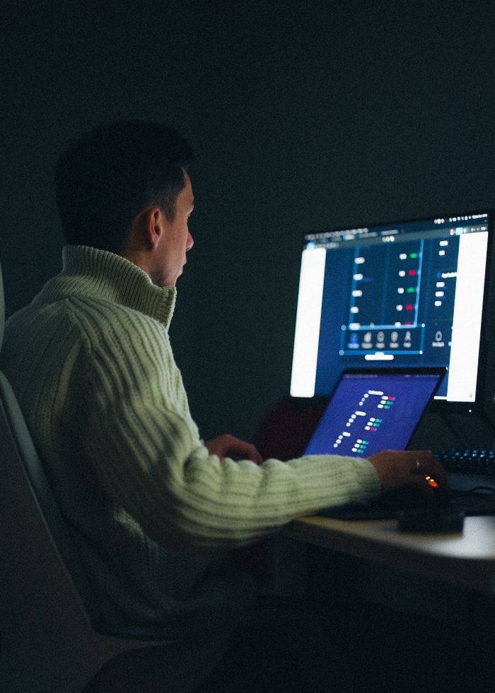 Mastering the First Impression: Your intriguing post title goes here Adult male working on a computer at night in a dark room.